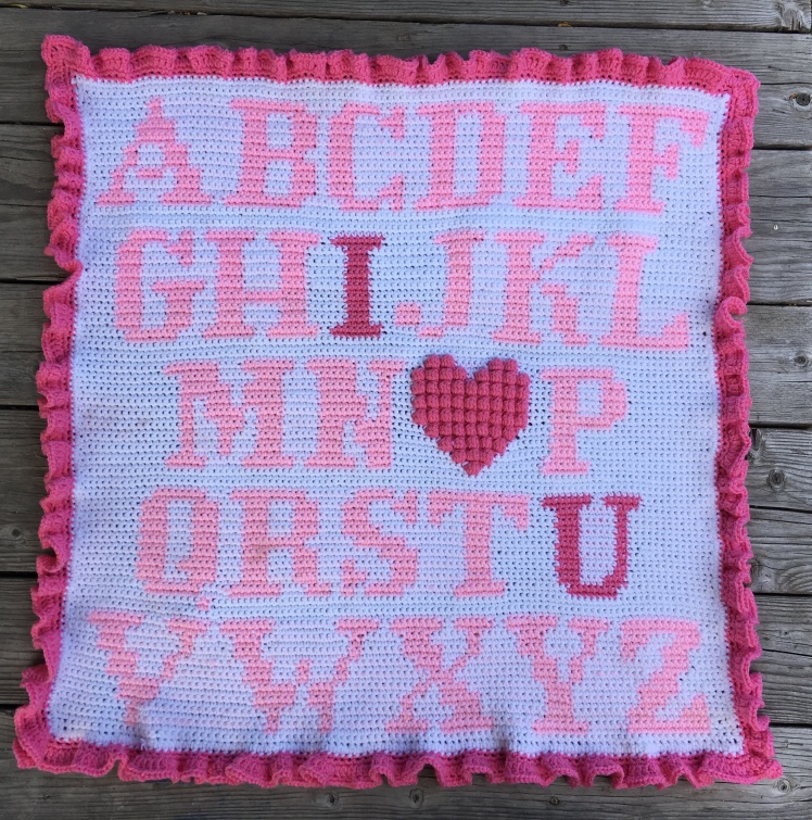 A simple alphabet graphghan featuring a textured bobble heart and a ruffle border.